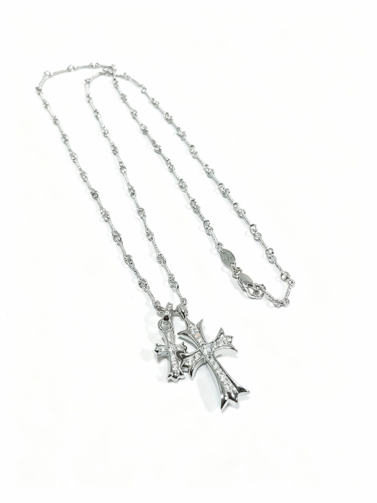 “Gold and silver double cross necklace flat lay showing zircon pendant and link chain”