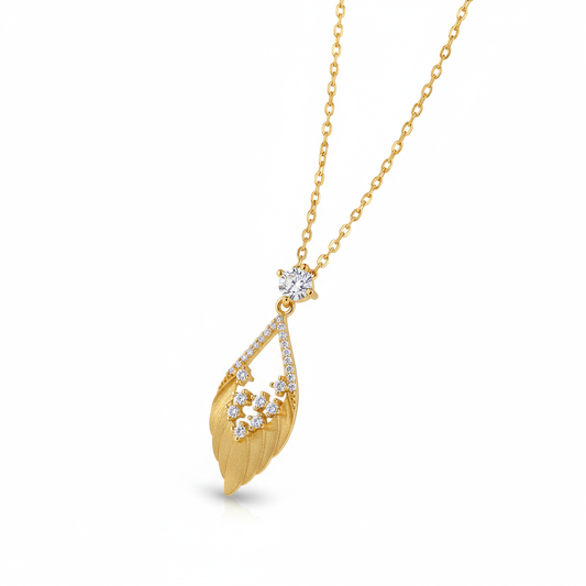 Gold necklace with a leaf-shaped pendant on a white background