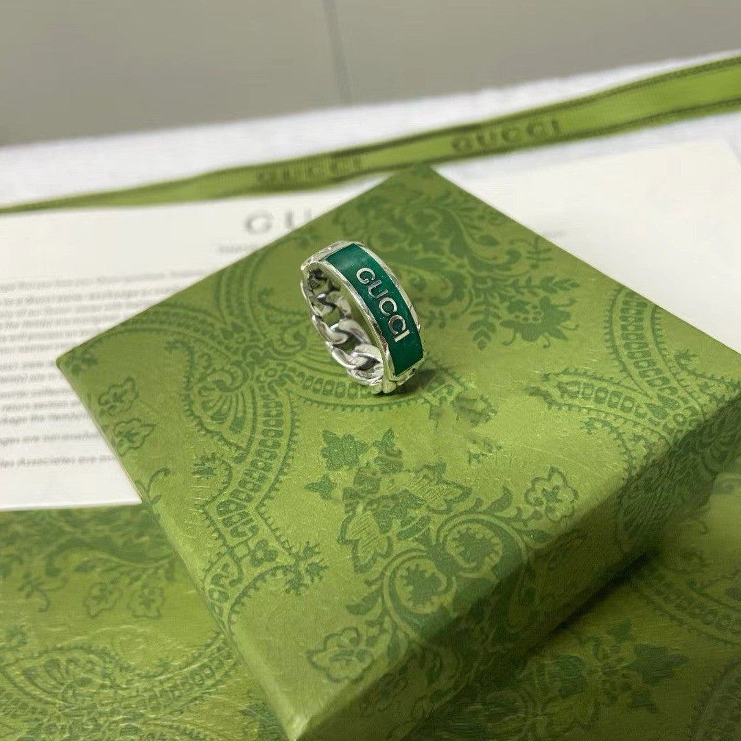 Gucci ring on a green patterned box with Gucci packaging in the background