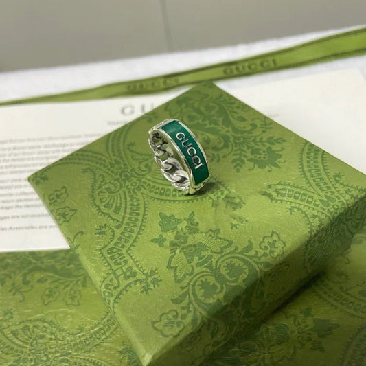 Gucci ring on a green patterned box with Gucci packaging in the background