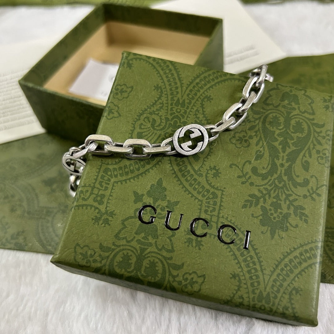 Gucci Interlocking chain bracelet on a green patterned box