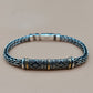Silver braided bracelet with decorative clasp on a beige background