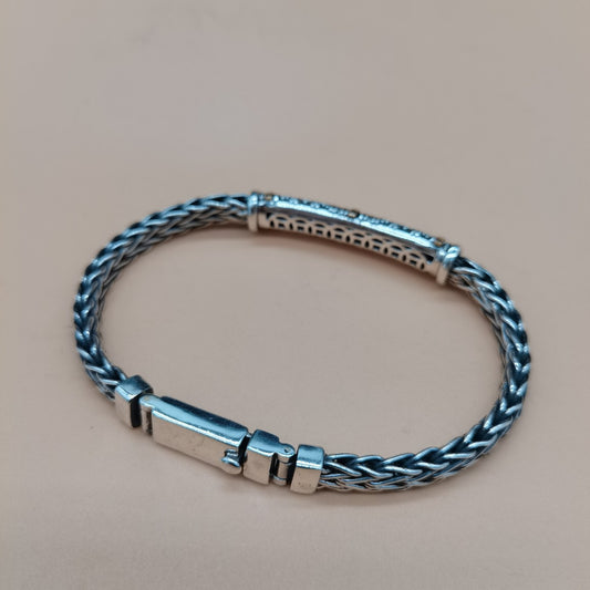 Silver braided bracelet on a beige background