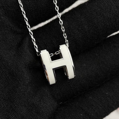 High-End “H” Enamel Pendant Necklace Silver necklace with a 'H' pendant on a black background