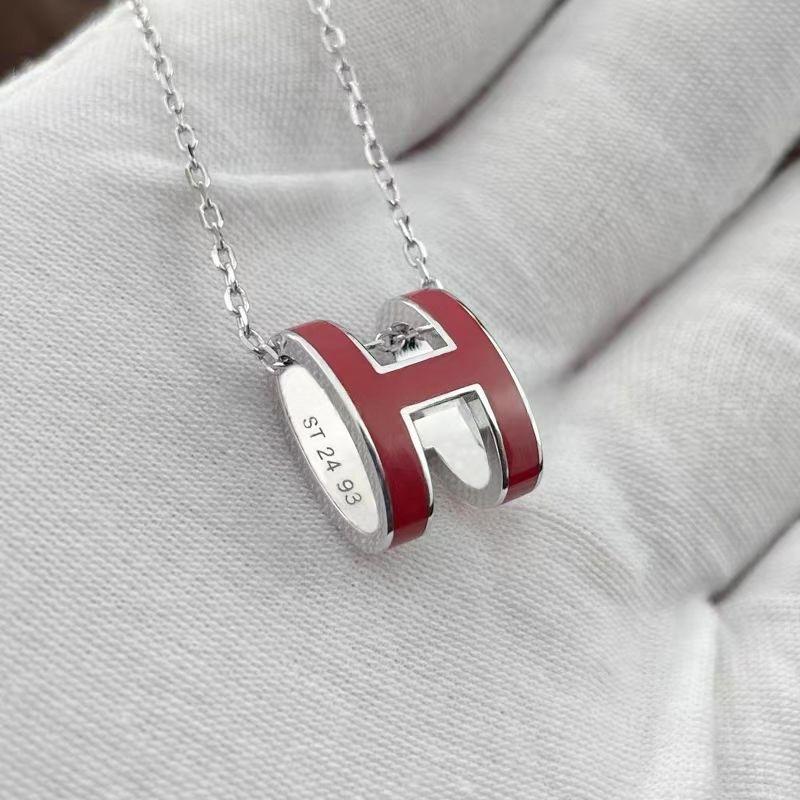 High-End “H” Enamel Pendant Necklace Silver and red 'H' pendant necklace on a light gray background