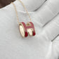 High-End “H” Enamel Pendant Necklace Necklace with a red and gold pendant on a light gray background