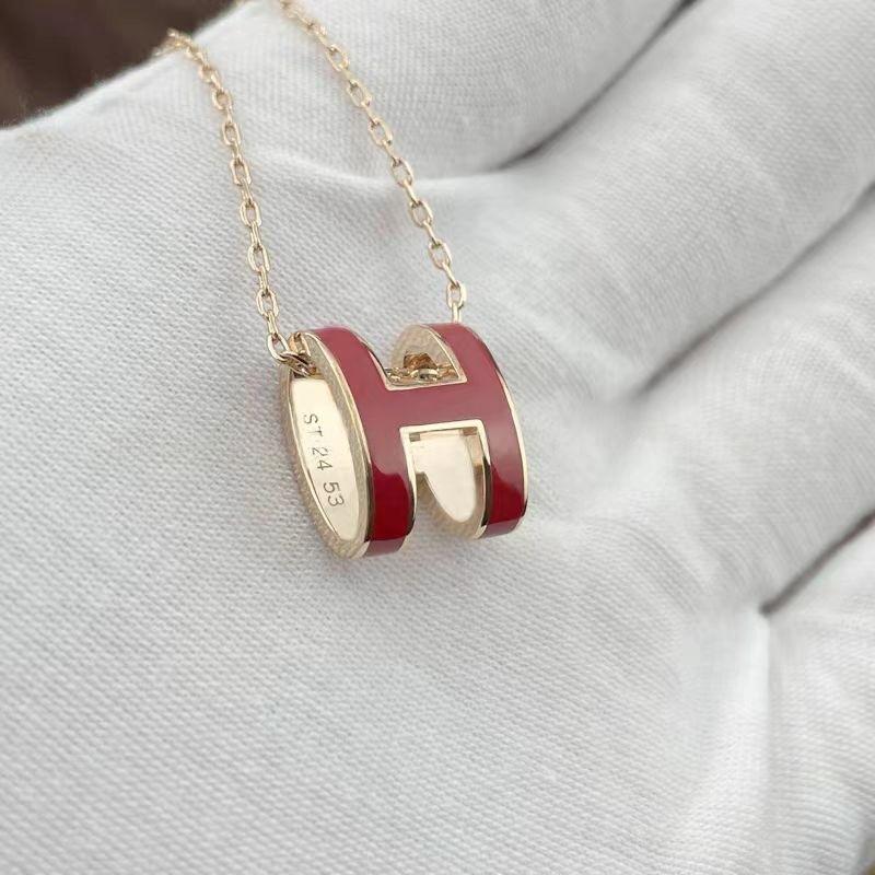 High-End “H” Enamel Pendant Necklace Necklace with a red and gold pendant on a light gray background