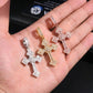 Four diamond cross pendants in different colors held in a hand.