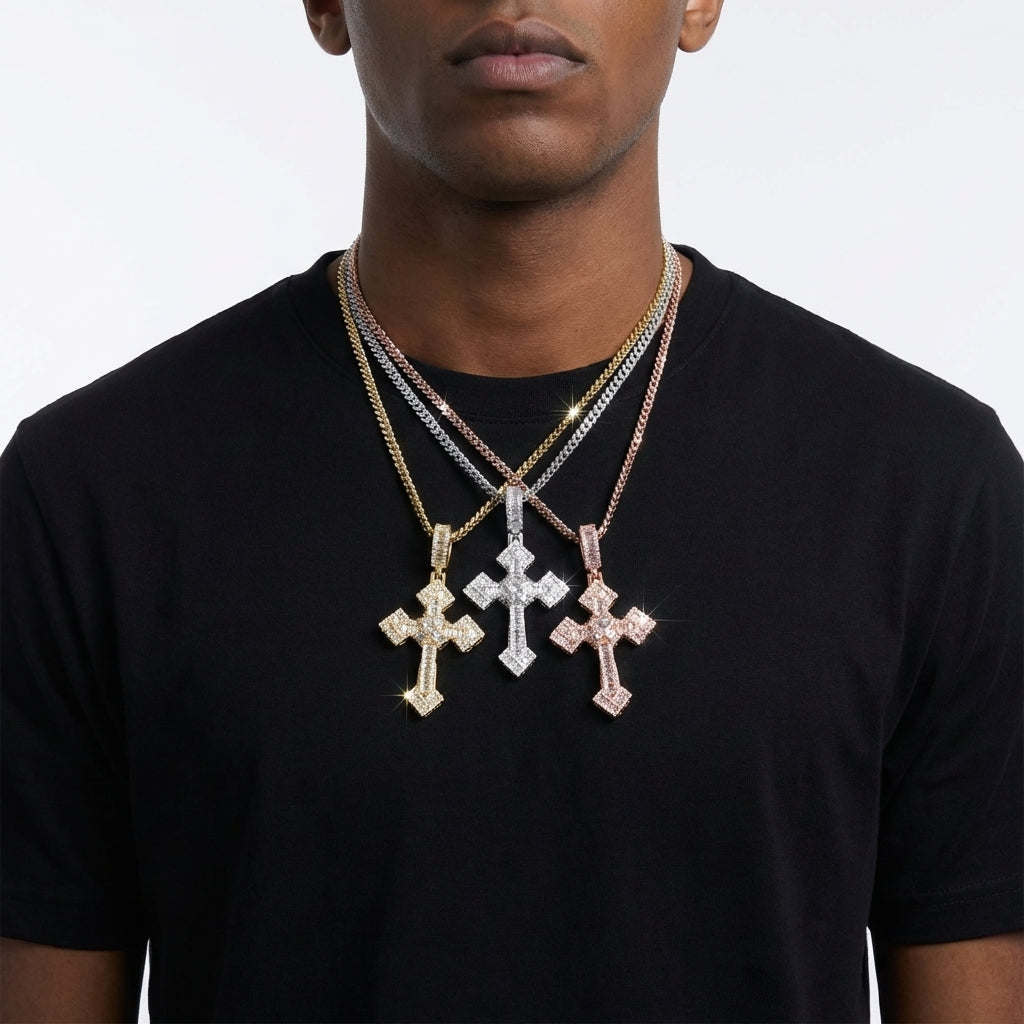 Man wearing three cross necklaces on a plain background