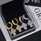 Gold and silver hoop earrings displayed in a jewelry box with a GIA moissanite report in the background.