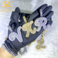 Black gloves with diamond-encrusted letter pendants on a white background