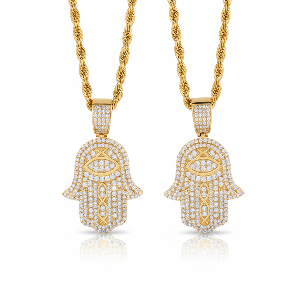 Two gold Hamsa hand pendants on chains against a white background