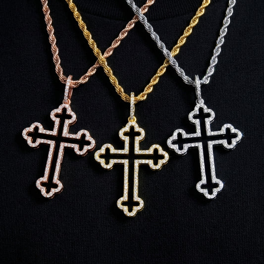 Three cross-shaped pendants on different colored chains against a black background