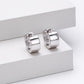 Pair of silver hoop earrings on a white surface