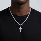 Person wearing a black shirt with a diamond-studded cross necklace.