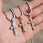 Three diamond-cross pendants on chains held in a hand.