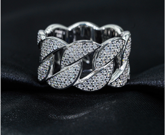 Silver bracelet with intricate design on a black fabric background
