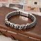 Silver braided bracelet on a brown leather surface