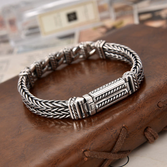Silver braided bracelet on a wooden surface