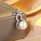Pearl necklace with silver pendant on a beige fabric background