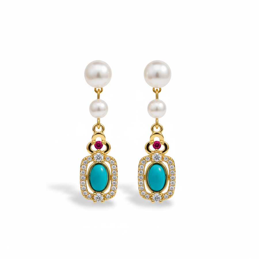 Pearl earrings with turquoise and red gemstones on a brown surface