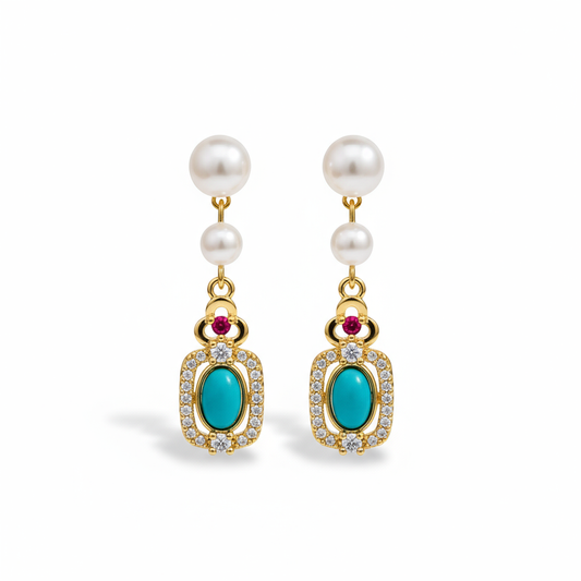 Pearl earrings with turquoise and red gemstones on a brown surface