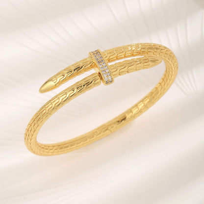 Gold bracelet with textured design on a light background