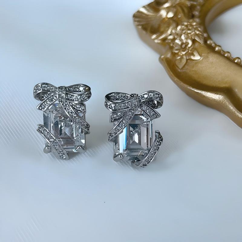 Clean shot of studs on a neutral or festive background (e.g., white marble or dark green velvet), highlighting the gift box shape and green pavé sparkle. Alt: “KATE SPADE Pavé Emerald Present Stud Earrings – Green Gift Box Design.”