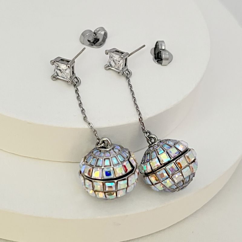 Earrings on a soft black or silver glitter background, showcasing the linear cascade of mirror tiles catching light. Alt: “Kate Spade Beaming Bright Disco Ball Linear Earrings – Mirror Tile Drop Jewelry.”