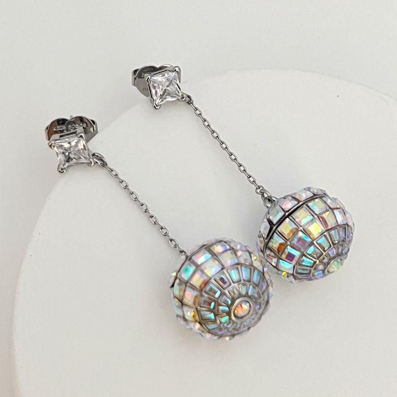 Earrings on a soft black or silver glitter background, showcasing the linear cascade of mirror tiles catching light. Alt: “Kate Spade Beaming Bright Disco Ball Linear Earrings – Mirror Tile Drop Jewelry.”