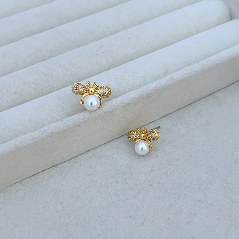 Earrings on a clean white or soft honeycomb-patterned background, showcasing the detailed bee design. Alt: “Kate Spade Bee Earrings – Gold Enamel Bee Stud Jewelry.”