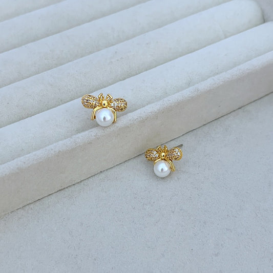 Earrings on a clean white or soft honeycomb-patterned background, showcasing the detailed bee design. Alt: “Kate Spade Bee Earrings – Gold Enamel Bee Stud Jewelry.”