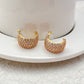 Gold-tone huggie hoops fully pavé-set with crystals on a soft white or champagne background. Alt: “Kate Spade Brilliant Statements Gold Pavé Huggies – Full Crystal Hoop Earrings.”
