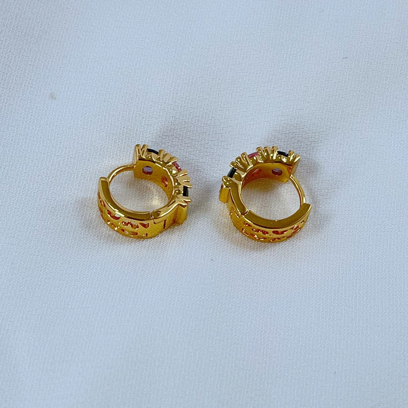 Earrings on a soft pastel pink or candy-striped background, showcasing the rainbow crystals along the gold hoop. Alt: “Kate Spade Candy Shop Small Stone Hoop Earrings – Rainbow Crystal Huggie Jewelry.”