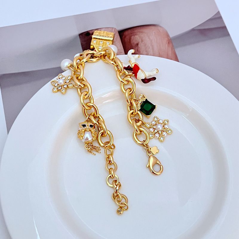 Macro focus on the carousel horse with its colorful saddle and the owl's detailed feather enamelwork. Alt: “Enamel Carousel Horse & Owl Charm Detail – Kate Spade.”