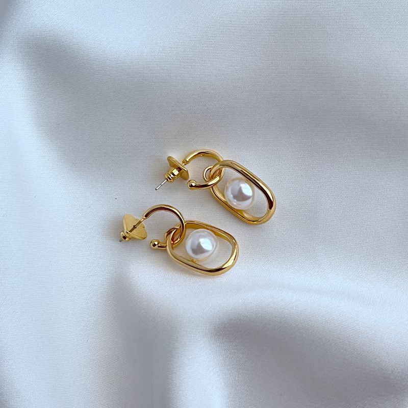 Earrings on a soft cream or dove grey background, showcasing the cascading gold links and luminous pearl drop. Alt: “Kate Spade Chain Reaction Gold Plated Link Drop Pearl Earrings – Modern Pearl Jewelry.”