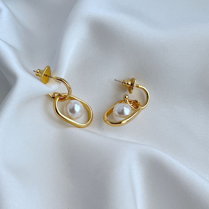 Earrings on a soft cream or dove grey background, showcasing the cascading gold links and luminous pearl drop. Alt: “Kate Spade Chain Reaction Gold Plated Link Drop Pearl Earrings – Modern Pearl Jewelry.”