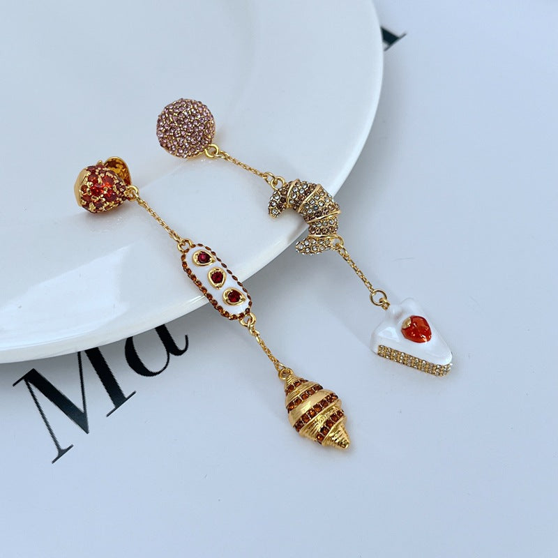  Earrings displayed side by side on a soft cream or café au lait background, showcasing the cherry shortcake and croissant charms. Alt: “Kate Spade Cherry Shortcake and Croissant Earrings – French Bakery Enamel Jewelry.”