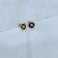 Clean, high-contrast shot of the necklace on a neutral background, highlighting the graphic interplay of gold and black on the clover.
