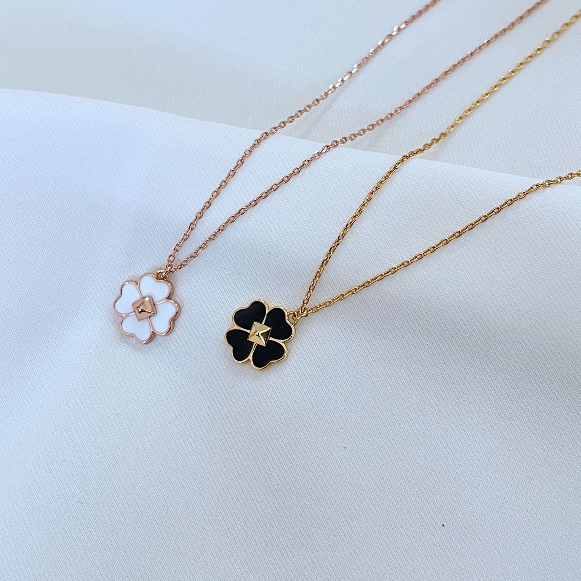 The necklace styled next to a deck of cards, a lucky coin, or on a minimalist surface, reinforcing themes of luck and modern design.