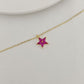 Gold necklace with a star-shaped pendant on a light gray background