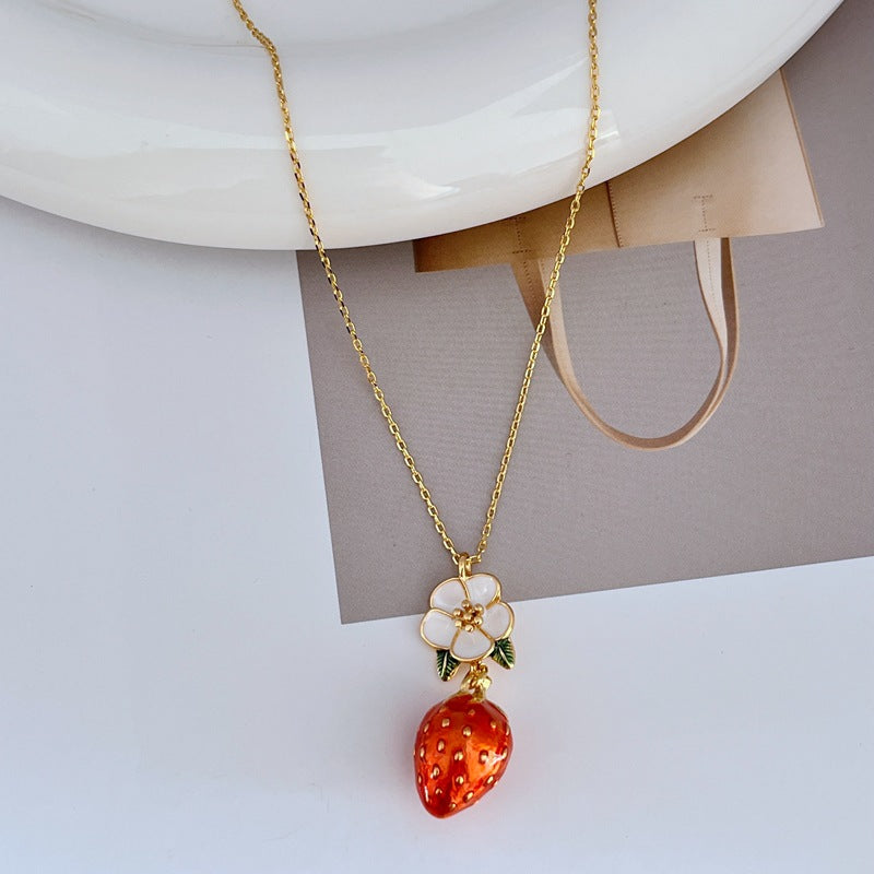 Necklace on a light pink or cream background, showcasing the strawberry pendant’s sparkle and shape. Alt: “Kate Spade Crystal Strawberry Pendant Necklace – Whimsical Jewelry for Women.