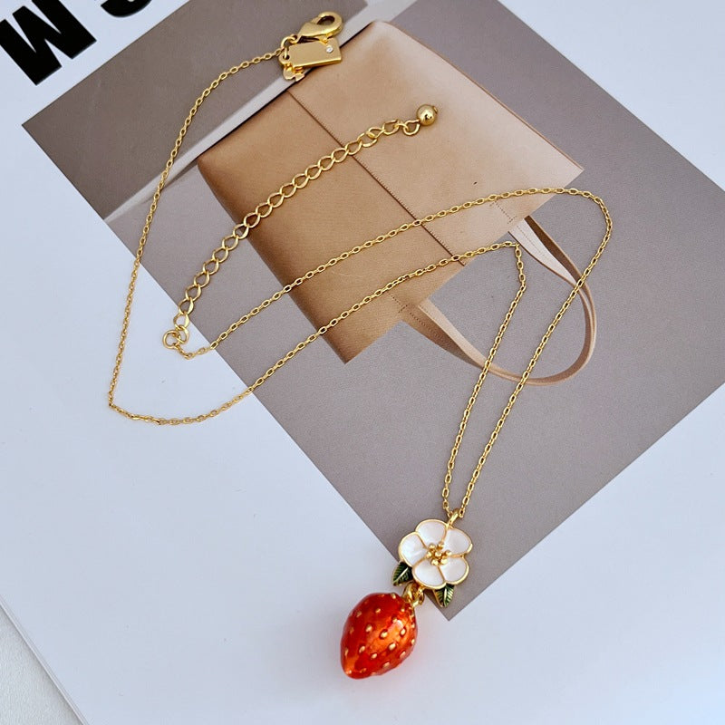 Necklace on a light pink or cream background, showcasing the strawberry pendant’s sparkle and shape. Alt: “Kate Spade Crystal Strawberry Pendant Necklace – Whimsical Jewelry for Women.