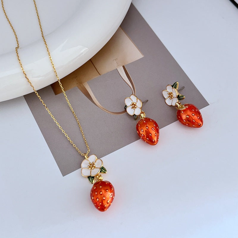 Necklace on a light pink or cream background, showcasing the strawberry pendant’s sparkle and shape. Alt: “Kate Spade Crystal Strawberry Pendant Necklace – Whimsical Jewelry for Women.
