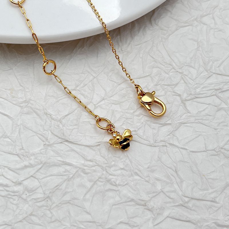 Macro focus on the daisy pendant, showing petal texture, center detail (crystal/enamel), and secure bail. Alt: “Detailed Daisy Pendant with Crystal Center – Kate Spade.