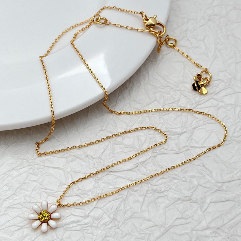  Daisy pendant necklace on a soft, light background (white or pale yellow), highlighting the floral detail and delicate chain. Alt: “Kate Spade Daisy Necklace – Delicate Floral Pendant Jewelry.”