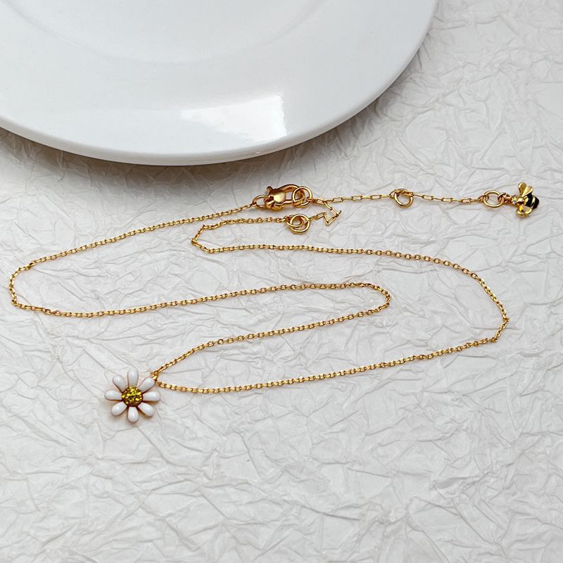  Daisy pendant necklace on a soft, light background (white or pale yellow), highlighting the floral detail and delicate chain. Alt: “Kate Spade Daisy Necklace – Delicate Floral Pendant Jewelry.”