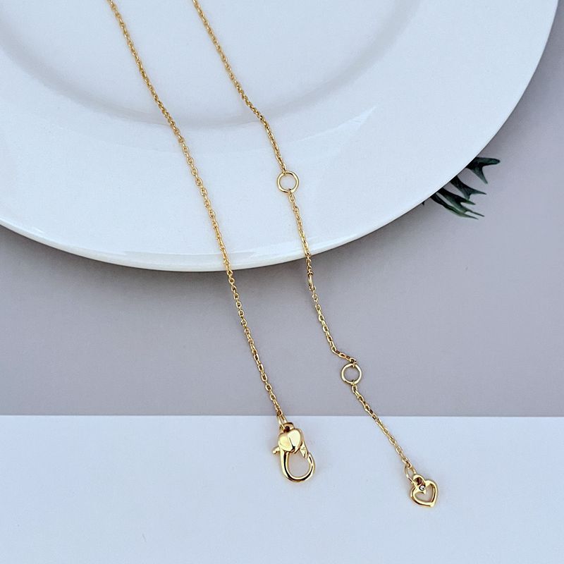 Necklace displayed against a soft pastel or marble background, highlighting the colorful charms. Alt: “Kate Spade Drink & Donut Necklace – Whimsical Food Charm Jewelry.”