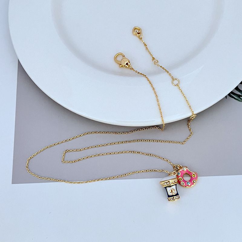 Macro shot focusing on the enamel donut sprinkles and drink detailing. Alt: “Colorful Enamel Donut & Drink Charm Details – Kate Spade.”