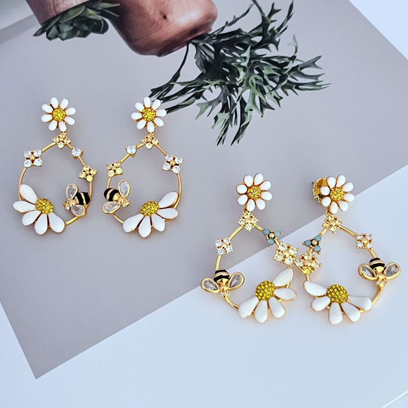  Earrings on a soft blush pink or garden green background, showcasing the pastel enamel flowers along the gold hoop. Alt: “Kate Spade Flower Hoop Earrings – Enamel Floral Hoop Jewelry.”